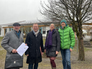 Alfred Seitz (BEG), Florian Mayer (Bürgermeister), Petra von Thienen (Umweltbeauftragte) und Bernhard Konrad (Projektentwicklung) zeigen den Vertrag vor den Photoltaikmodulen auf dem Dach der Kinderhauses.